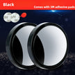 Two round black mirrors with adhesive pads on a dark background