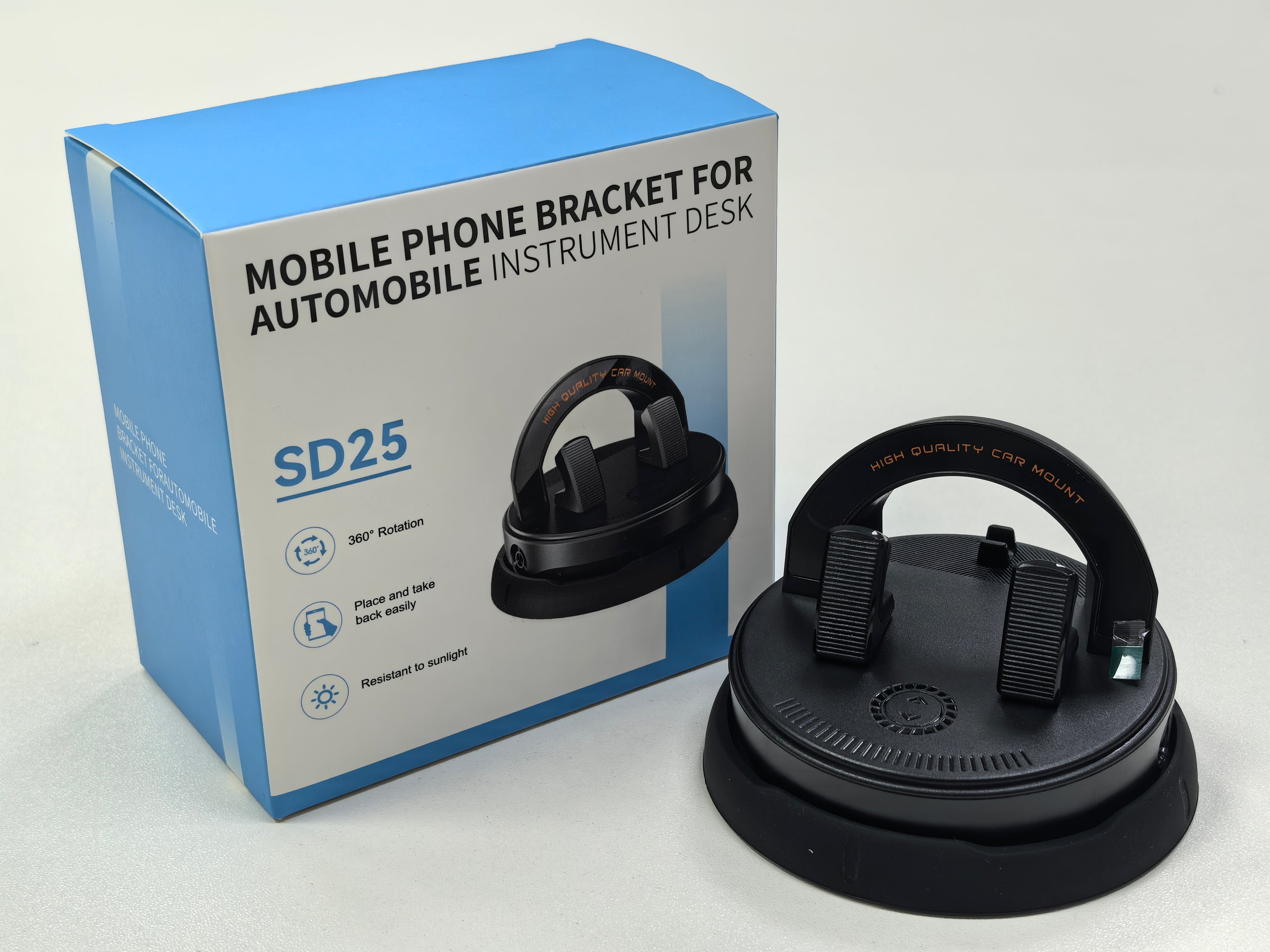 Black mobile phone bracket for automobile instrument desk with packaging on a light gray background