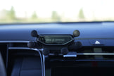 Phone holder on a car dashboard with 'This is Spring' text