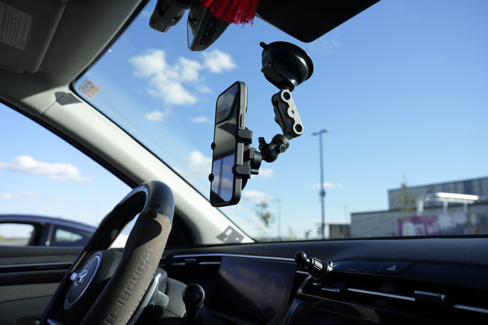 Car interior with a phone mount on the dashboard and rearview mirror.