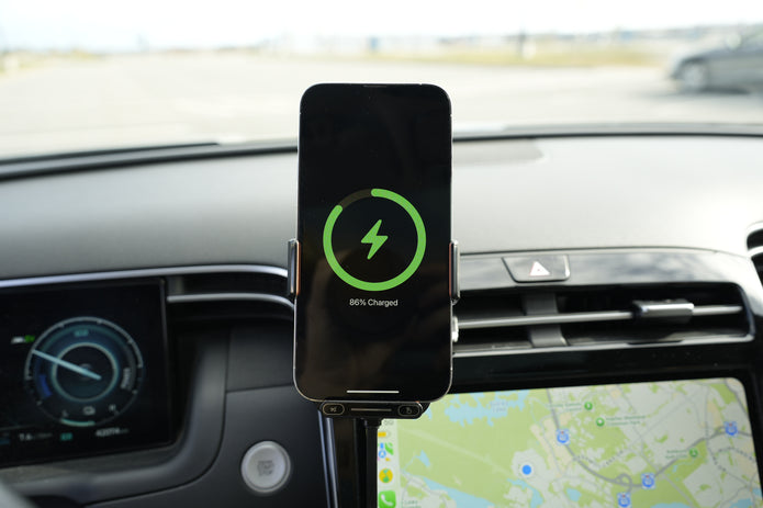 Phone mounted on a car dashboard with charging indicator