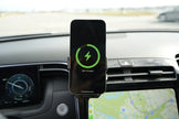 Phone mounted on a car dashboard with charging indicator