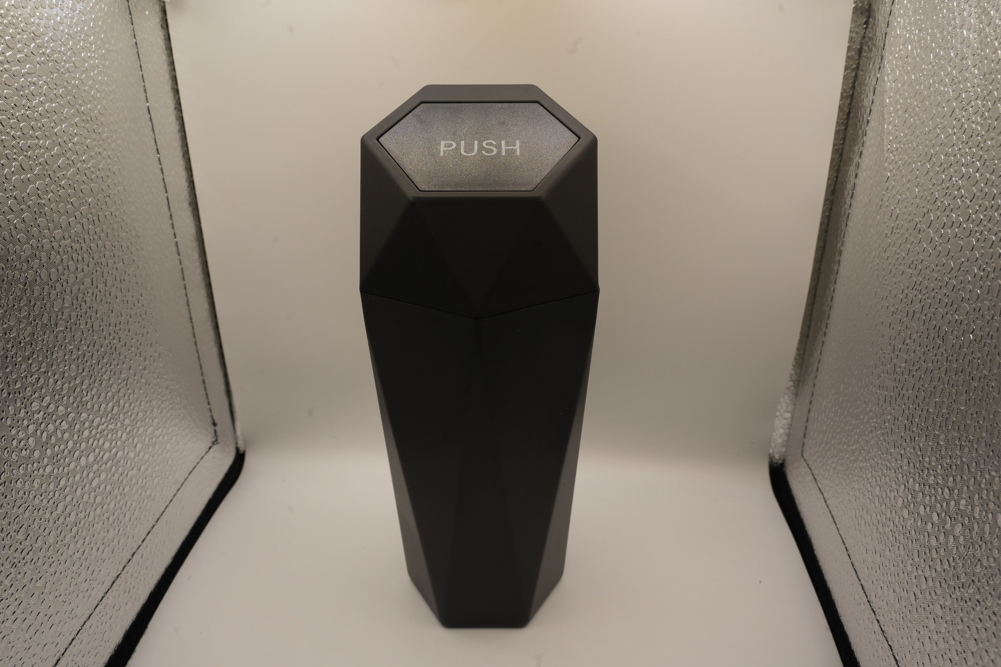 Black hexagonal object with 'PUSH' text on a white background