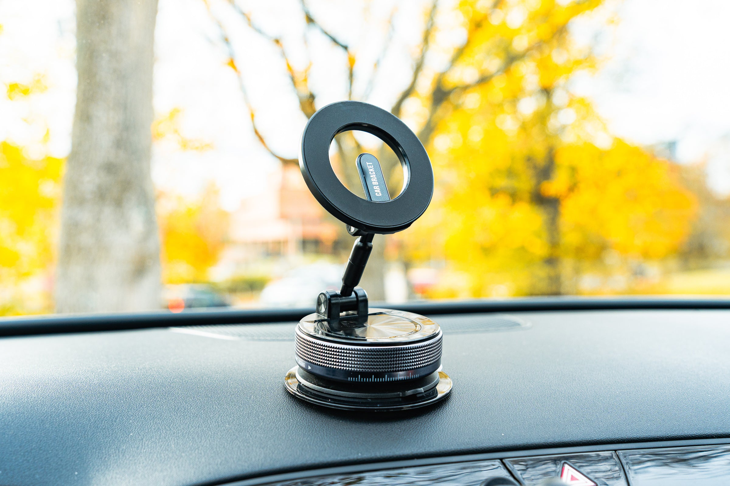 Car dashboard with a phone holder and ring light, blurred outdoor background