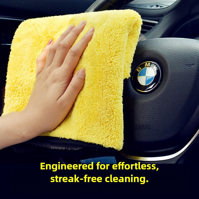 Hand using a yellow microfiber cloth to clean a BMW car interior.