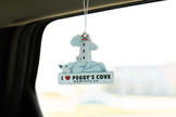 Car air freshener with a lighthouse design hanging from a car's rearview mirror.