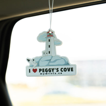 Car air freshener with a lighthouse design hanging from a car's rearview mirror.