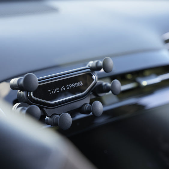 Car air freshener with 'This is Spring' text on a car dashboard