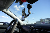 Car interior with a phone mount on the dashboard and rearview mirror.