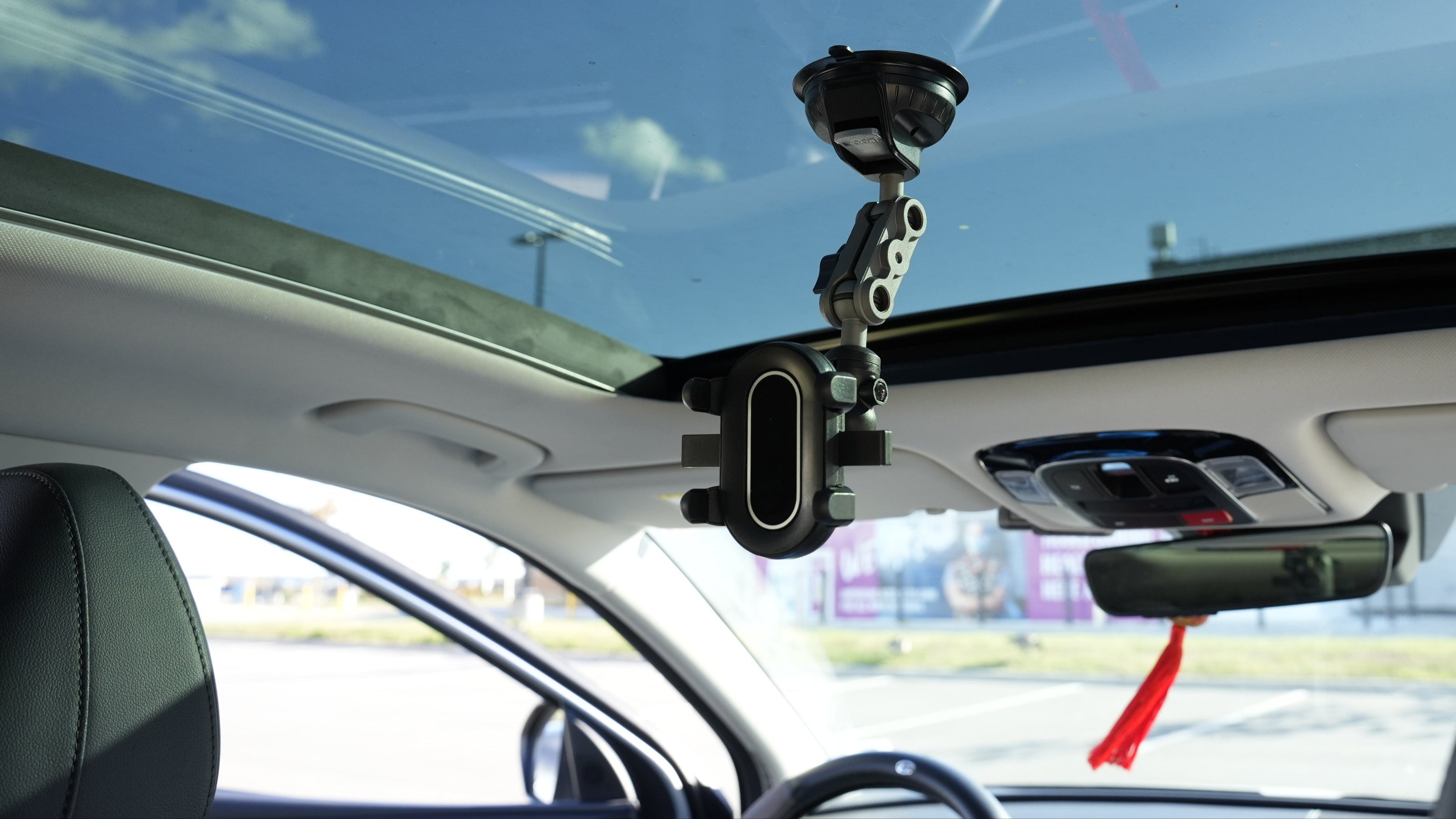 Car interior with a mounted phone holder and camera on the windshield.