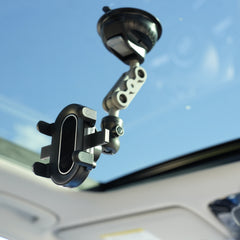 Car phone mount attached to a car's sun visor with a clear blue sky background.