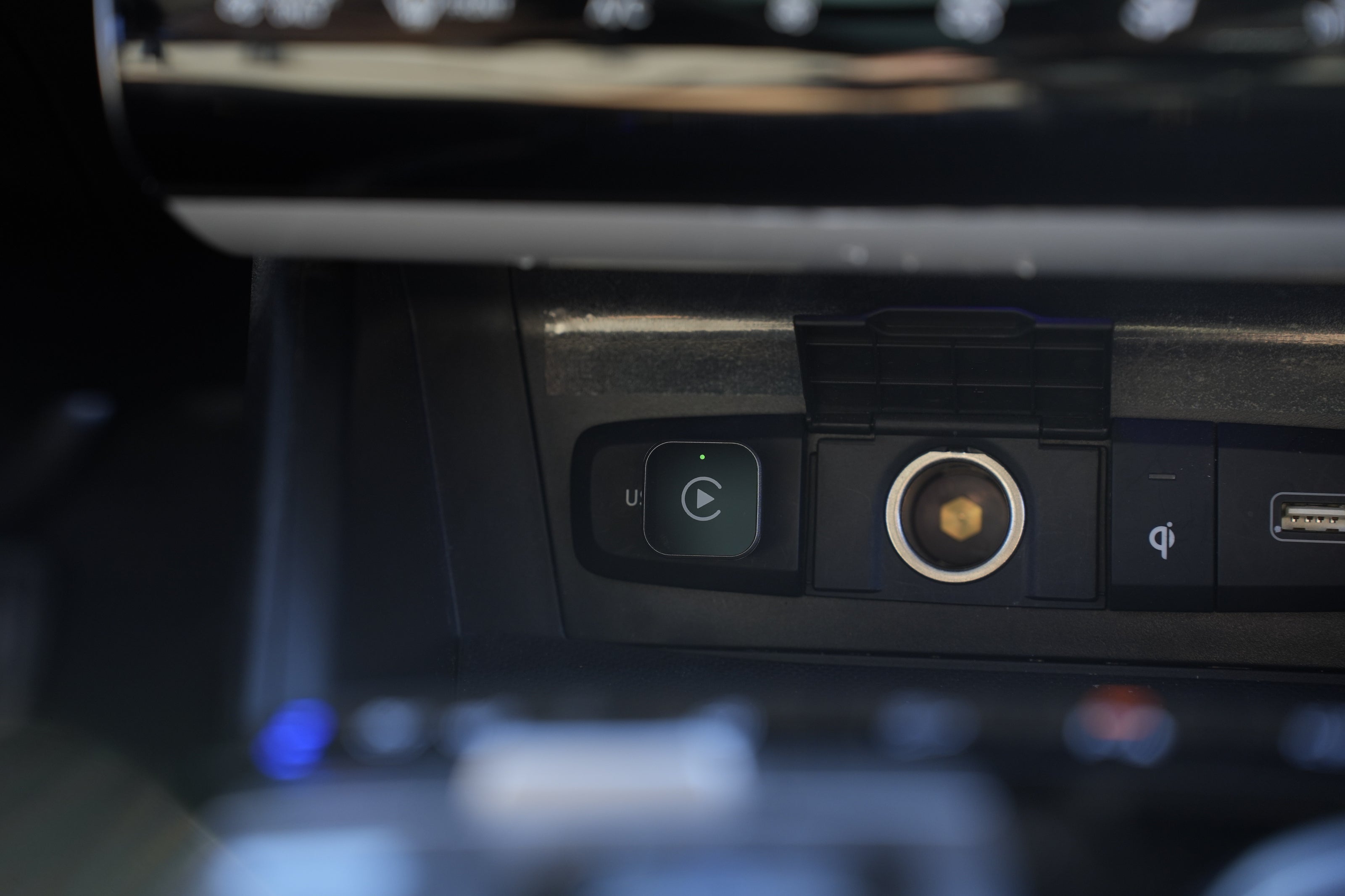 Close-up of a car's multimedia control panel with buttons and camera lens.