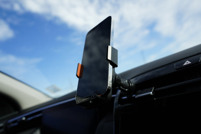 Phone mount on car dashboard with blue sky background