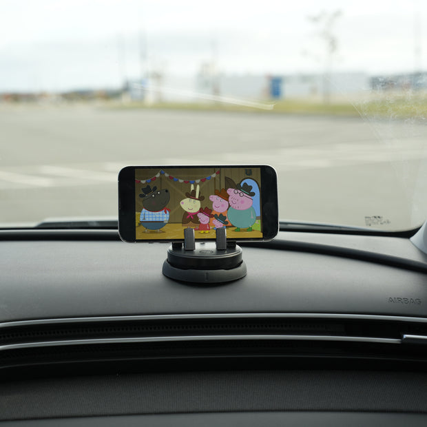 Phone mounted on a car dashboard displaying an app with cartoon characters.