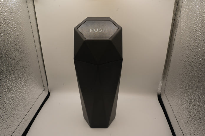 Black hexagonal object with 'PUSH' text on a white background