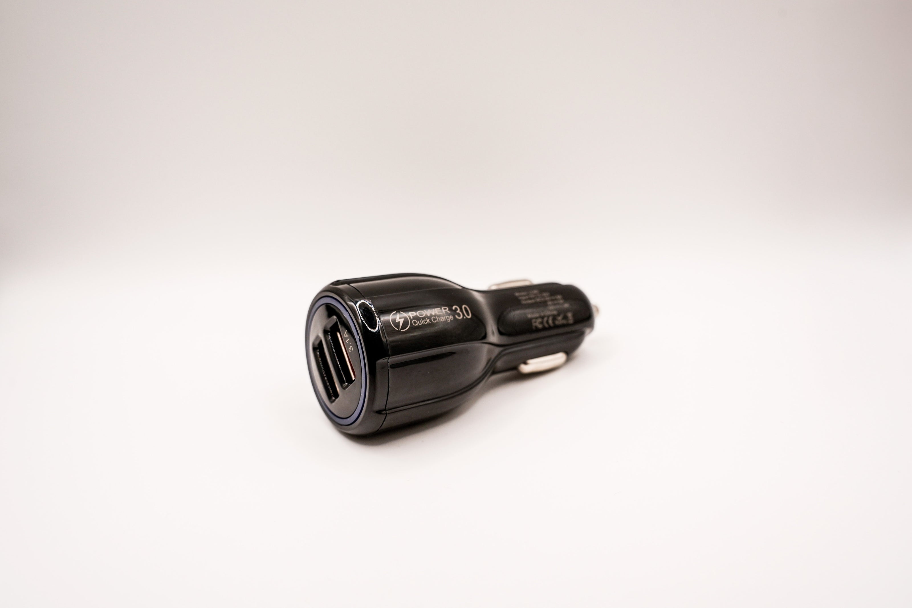 Black car charger with two USB ports on a white background
