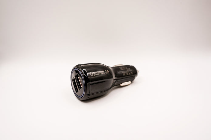 Black car charger with two USB ports on a white background