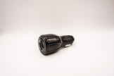 Black car charger with two USB ports on a white background