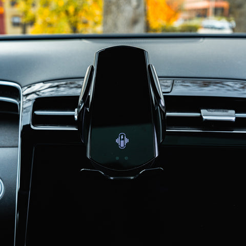 Car phone holder on a car dashboard with blurred outdoor background