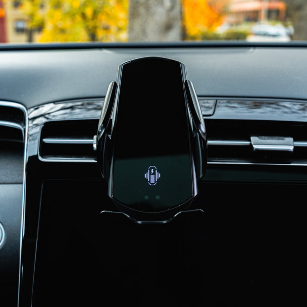 Car phone holder on a car dashboard with blurred outdoor background
