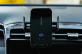 Phone mounted on a car dashboard with a charging app displayed