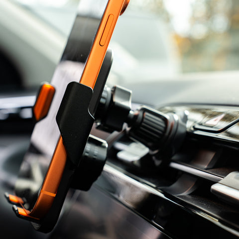 Phone holder on a car dashboard with a blurred background