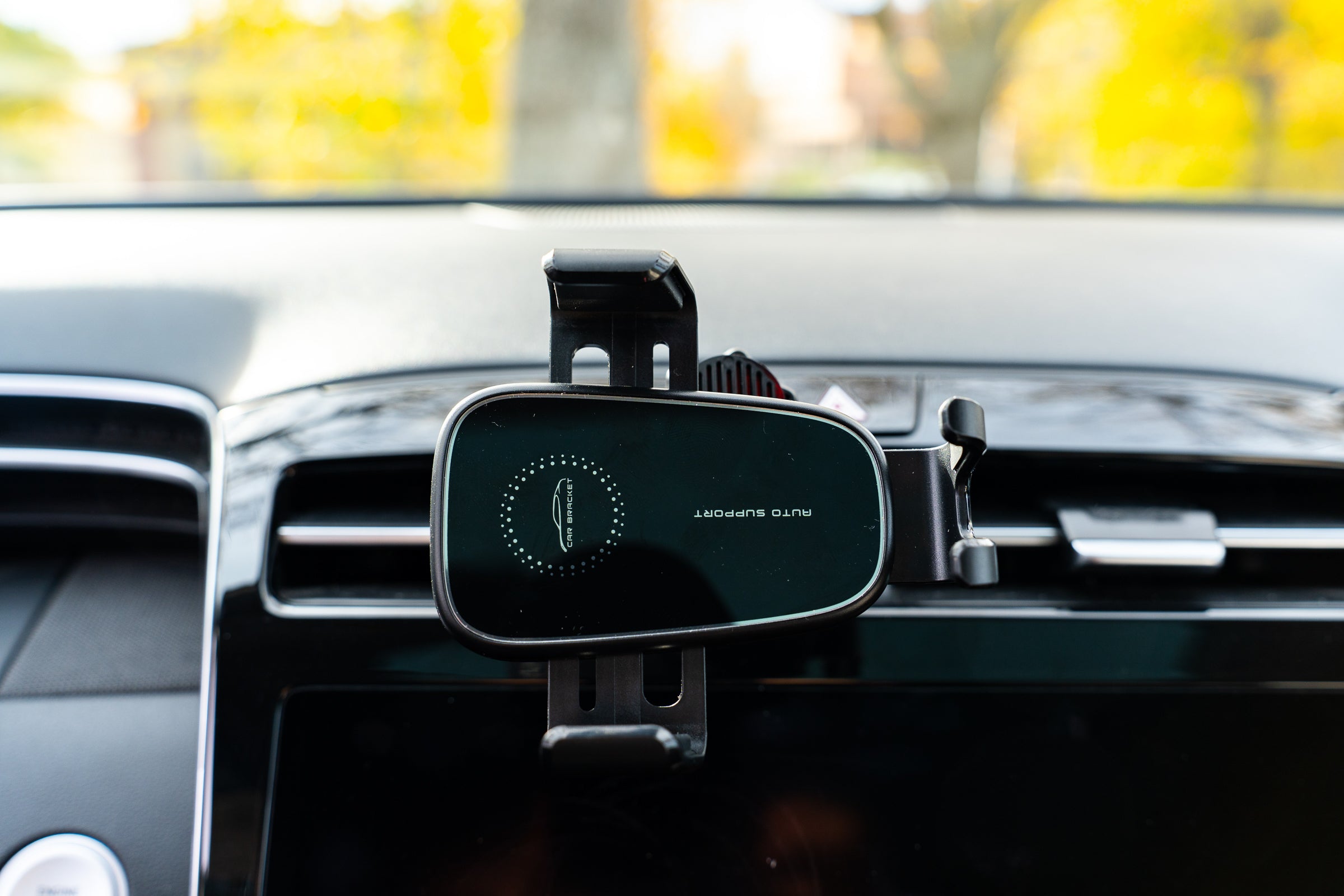 Car phone mount with brand logo on a car dashboard