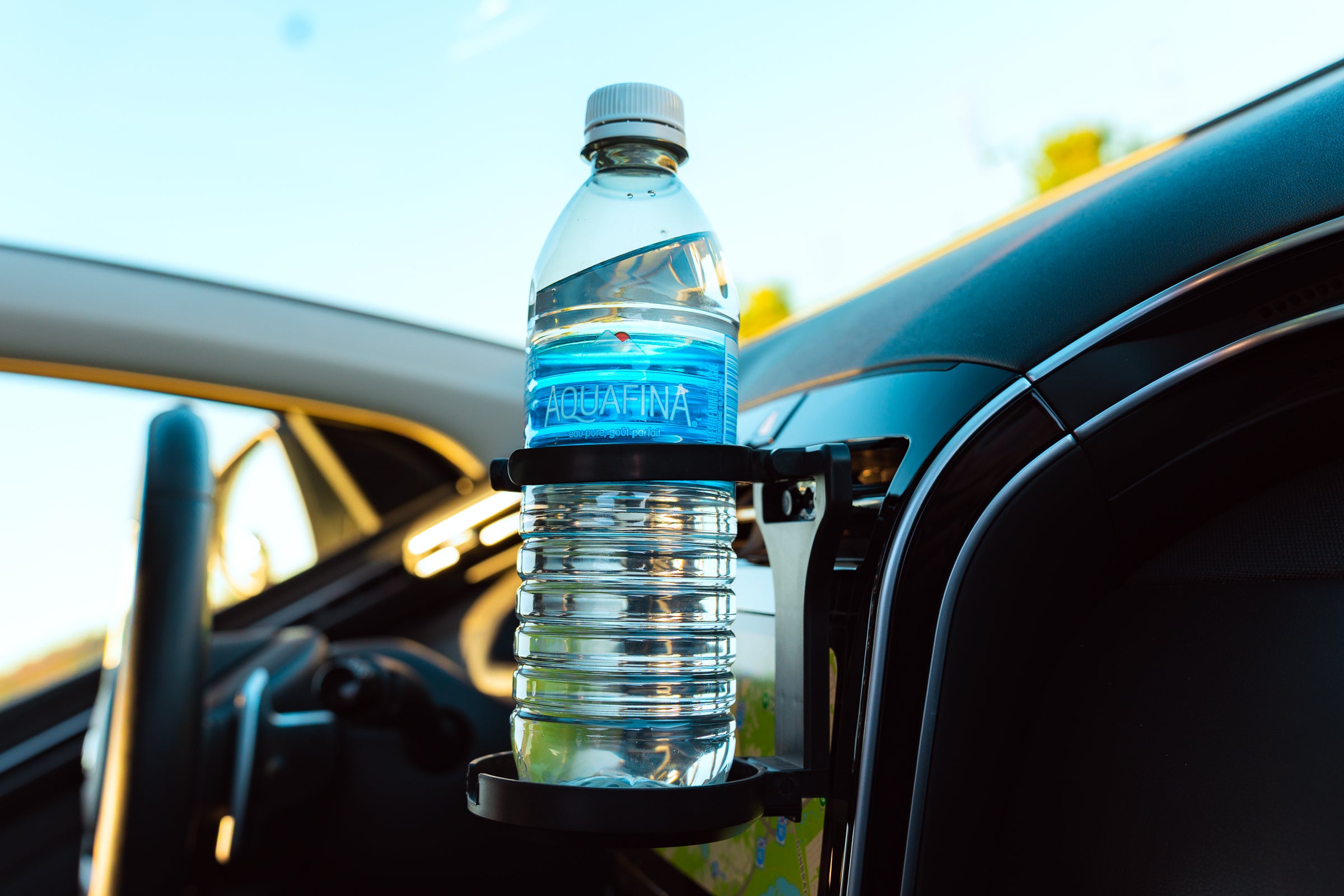 Water bottle in a car holder with a car's interior in the background
