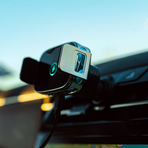 Car dashboard with a GPS device attached, blurred outdoor background