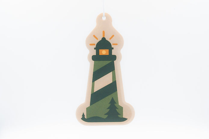 Decorative lighthouse ornament with green and beige stripes on a white background