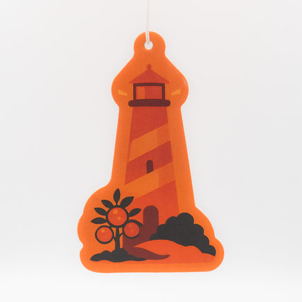 Orange lighthouse-shaped air freshener on a white background