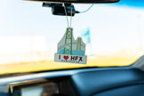 Car air freshener with 'I ❤️ HFX' text hanging from a car's rearview mirror.